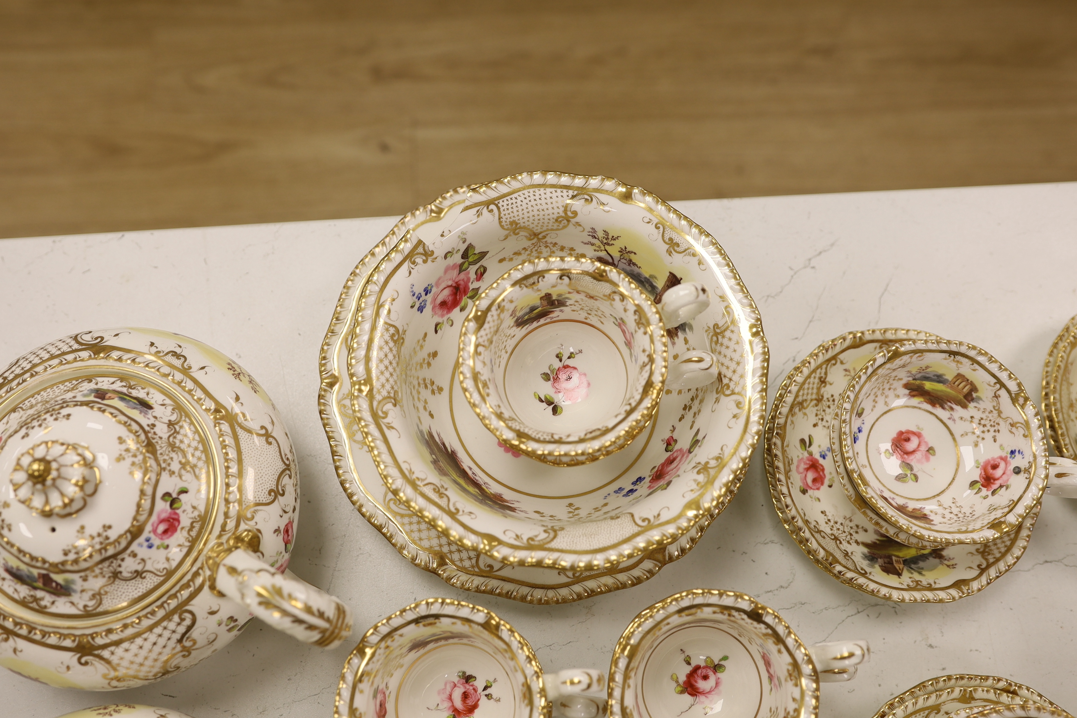 An early 19th century H & R Daniel landscape painted tea and coffee set, including twelve tea cups and saucers, twelve coffee cups, a teapot, a jug and a covered serving bowl, teapot 15cm high